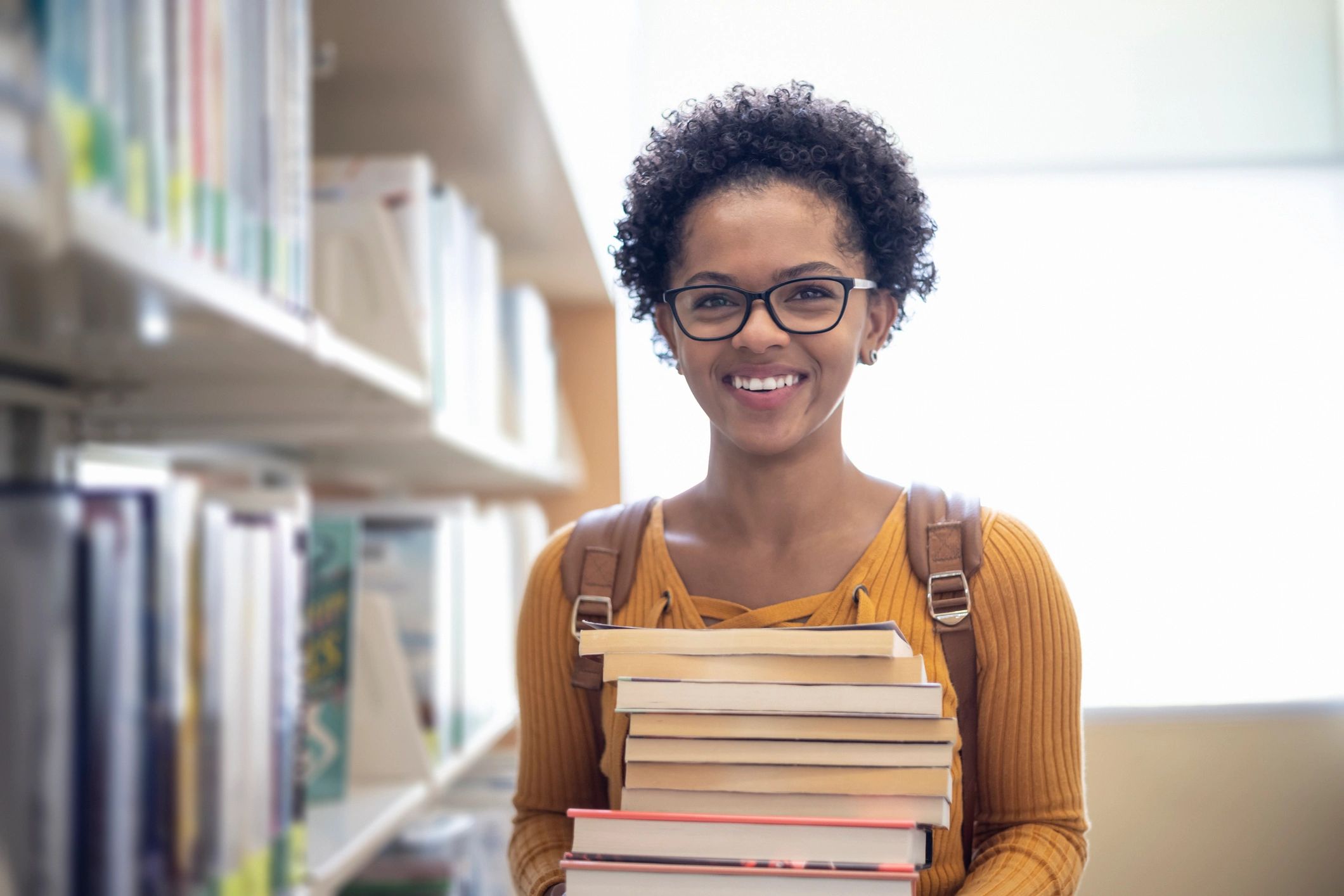 Student studying independently with books in a library