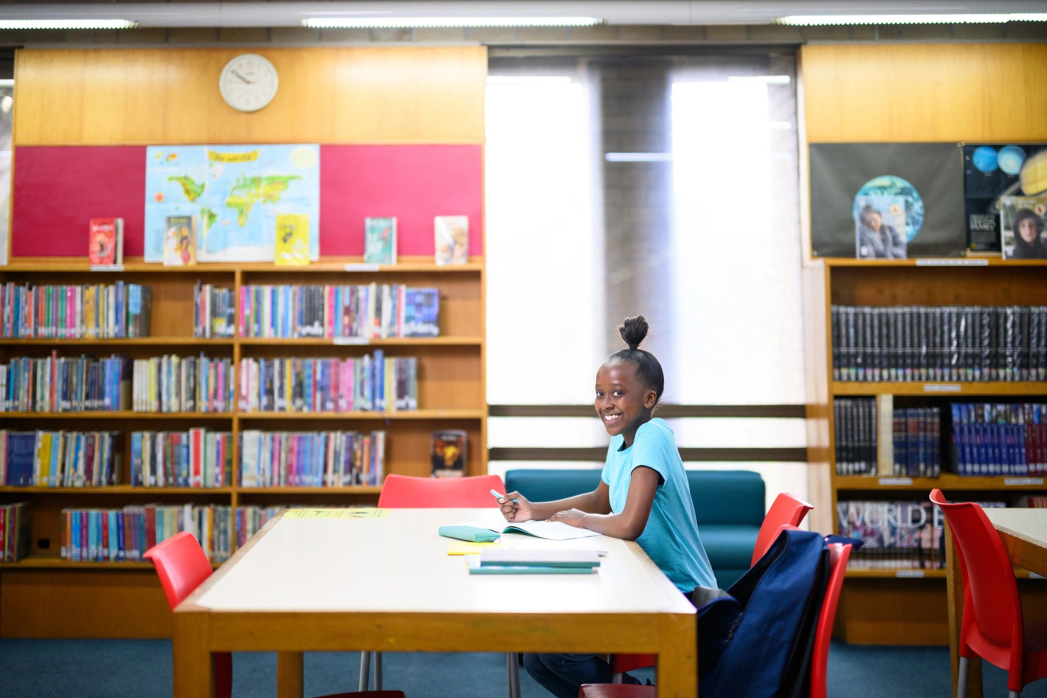 Teenage girl doing homework in library