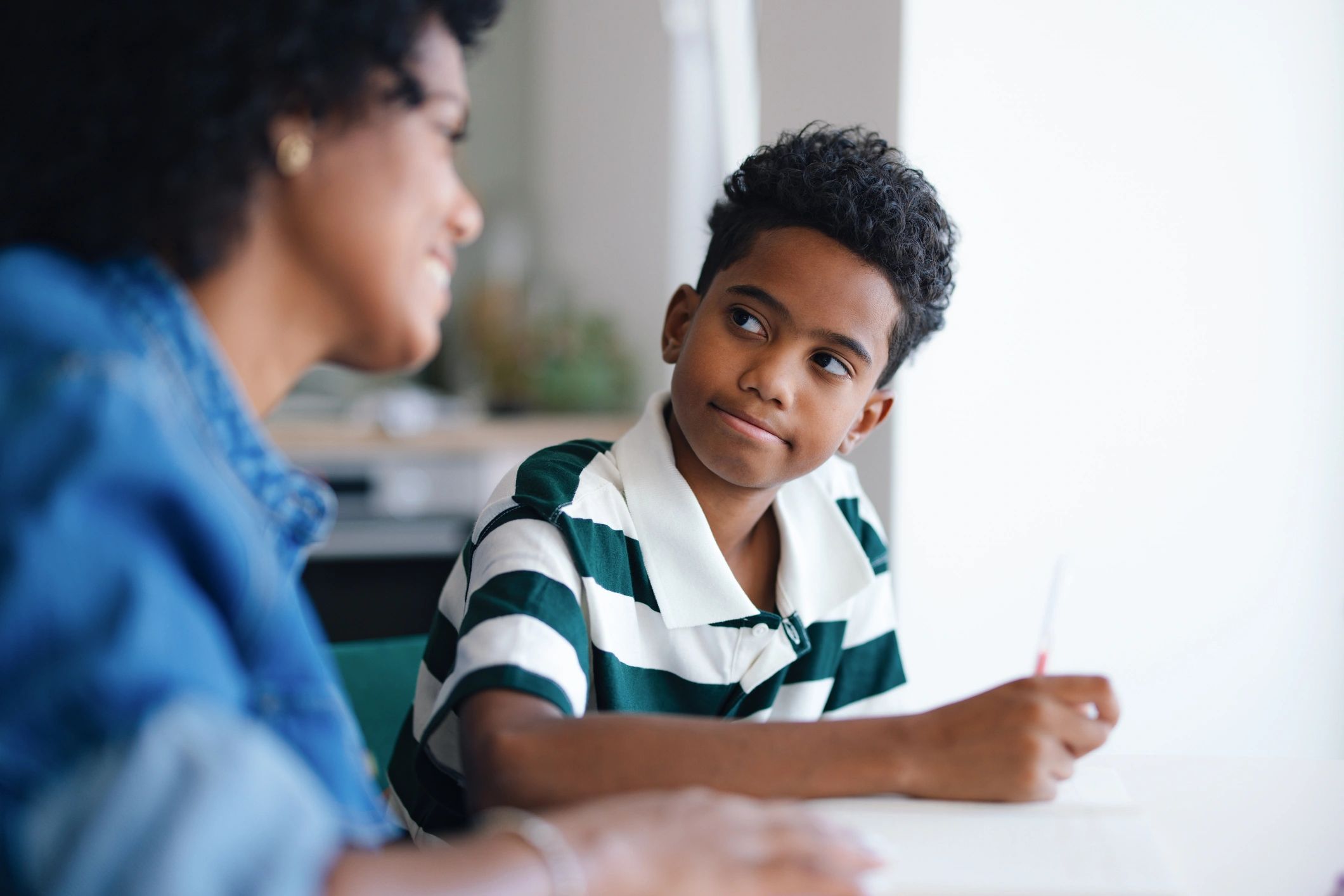 Parent supporting a child with homework at a table